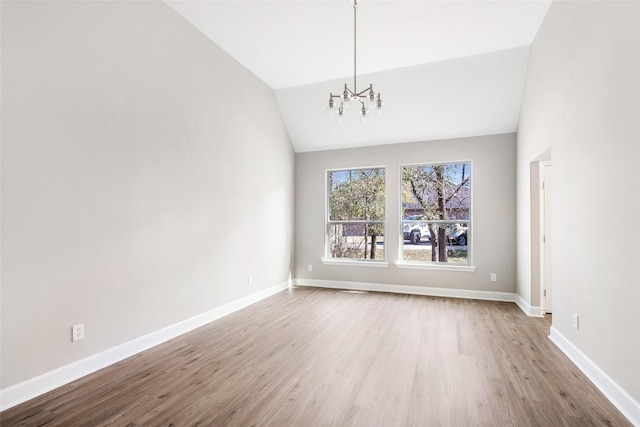 unfurnished dining area featuring an inviting chandelier, lofted ceiling, and light hardwood / wood-style flooring