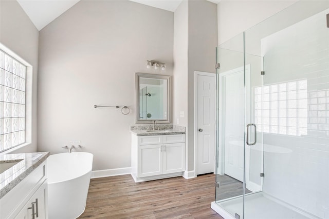 bathroom featuring plus walk in shower, lofted ceiling, hardwood / wood-style flooring, and vanity