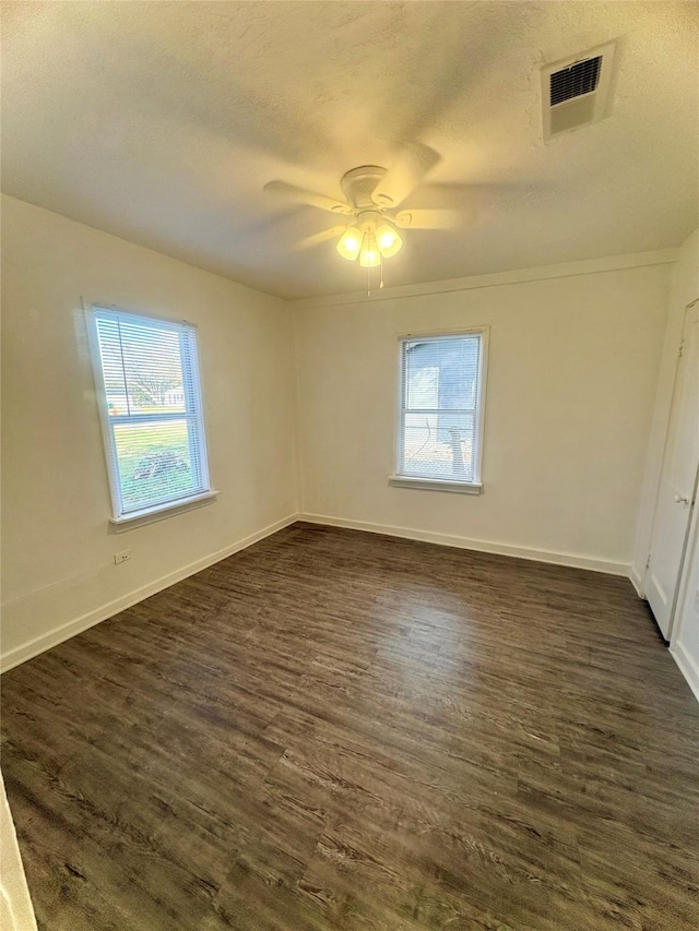 spare room featuring a textured ceiling, dark wood-type flooring, and ceiling fan