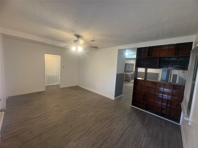 living room featuring a textured ceiling, dark wood-type flooring, and ceiling fan