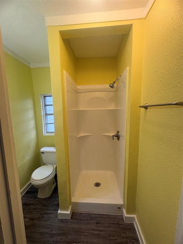 bathroom with walk in shower, toilet, ornamental molding, and hardwood / wood-style flooring