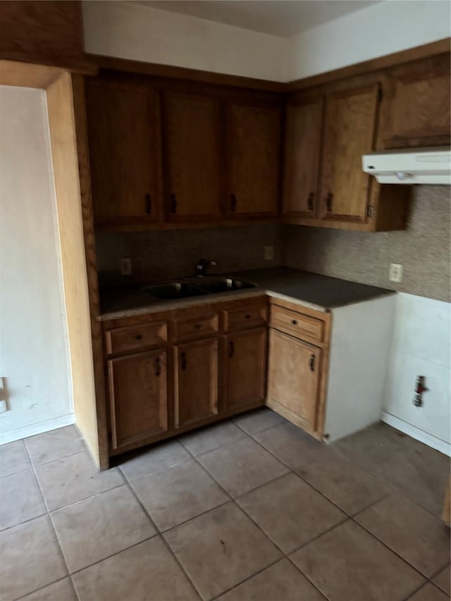 kitchen with decorative backsplash, sink, light tile patterned floors, and range hood