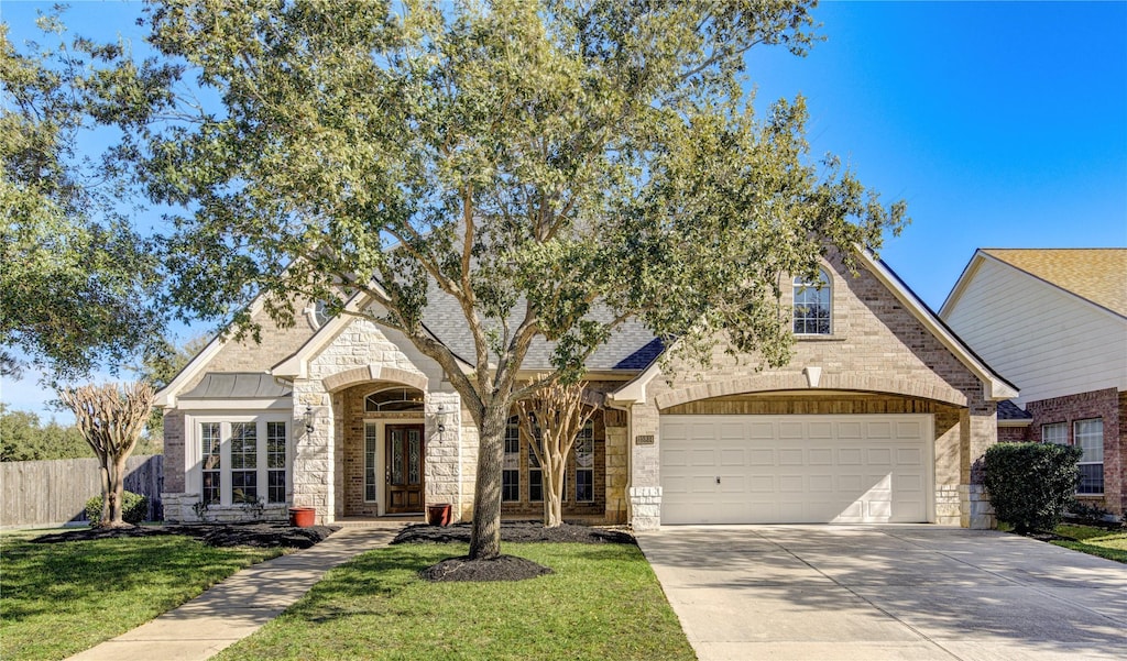 view of front of property featuring a front yard and a garage