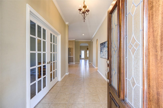 hall with light tile patterned floors, crown molding, and french doors