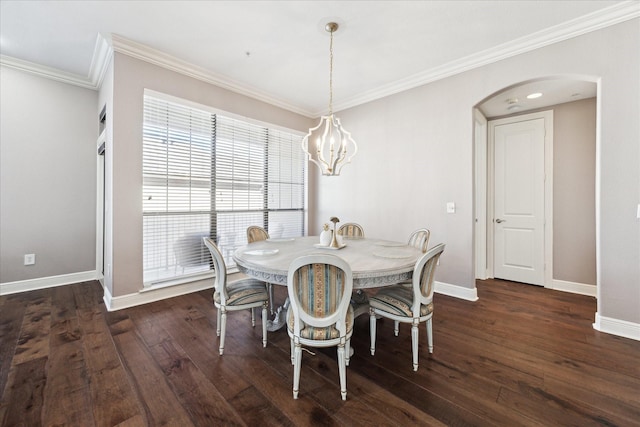 dining area with dark wood-type flooring, ornamental molding, and a chandelier