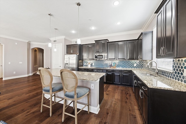 kitchen with sink, a center island, appliances with stainless steel finishes, dark hardwood / wood-style flooring, and pendant lighting