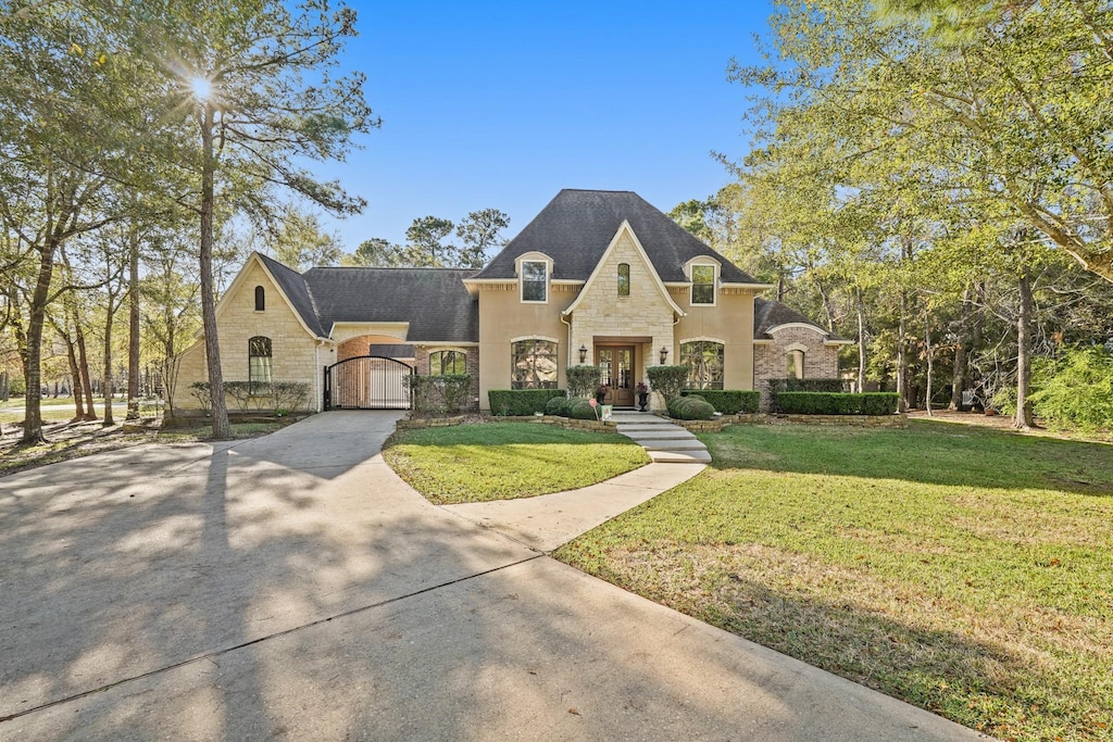 french country inspired facade with a front lawn