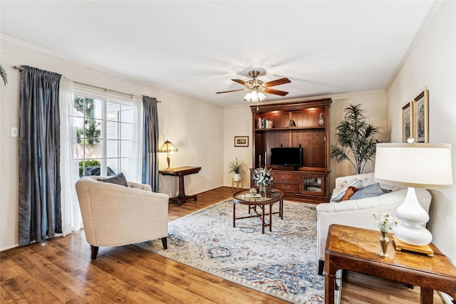 living room featuring ceiling fan, ornamental molding, and hardwood / wood-style floors