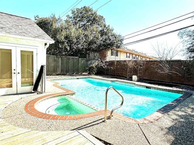 view of swimming pool featuring french doors and an in ground hot tub