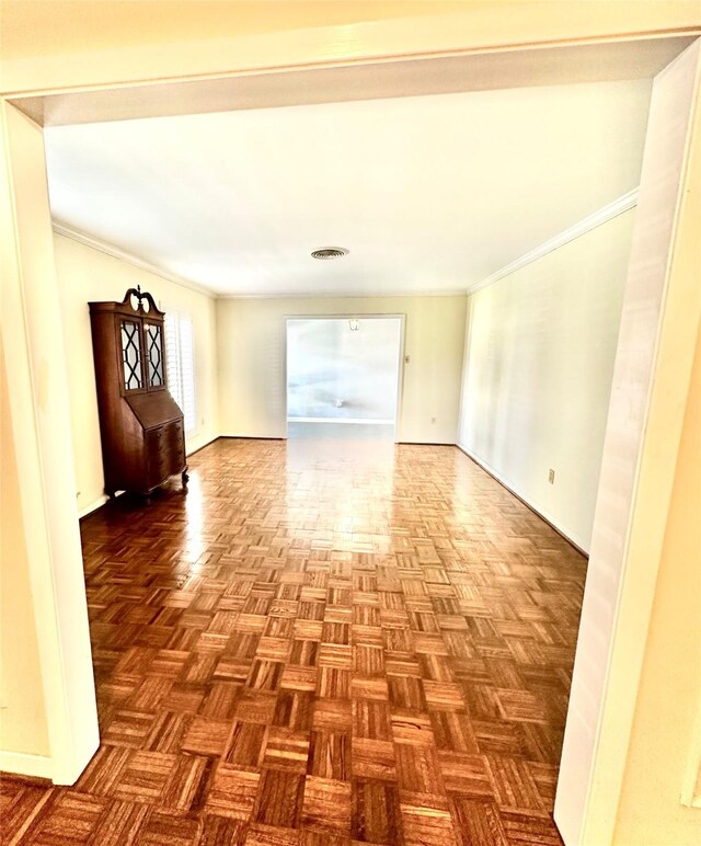 spare room featuring parquet floors and crown molding