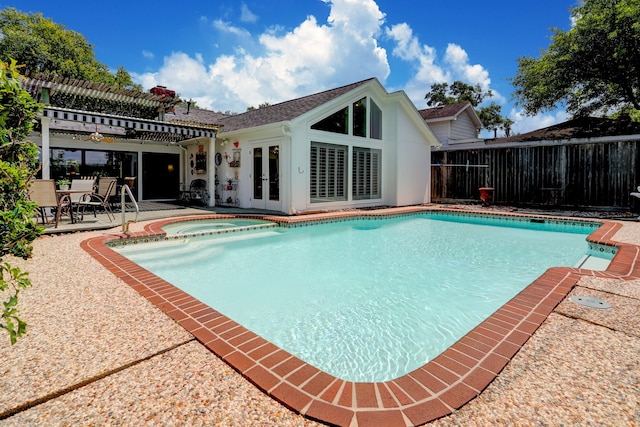 view of pool with a patio, fence, a pergola, a pool with connected hot tub, and french doors