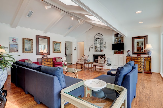 6143 Ella Lee Ln, Houston, TX 77057 - living area featuring light wood-style floors, lofted ceiling with beams, rail lighting, and visible vents