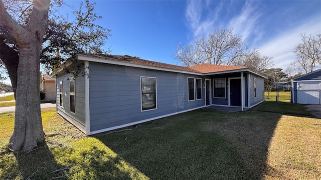 rear view of property featuring a lawn