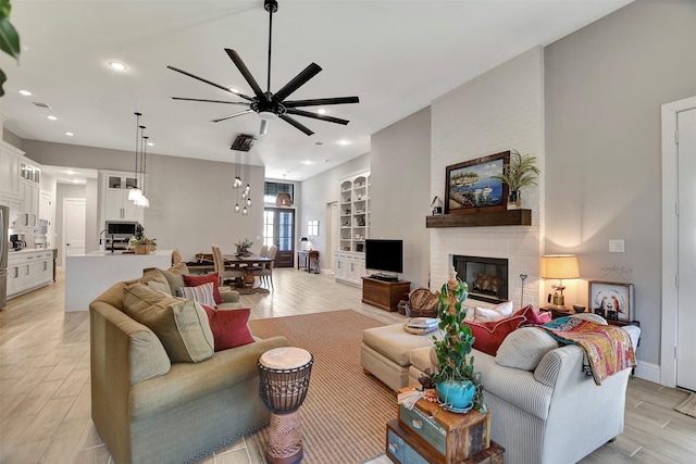 living room with ceiling fan and a brick fireplace