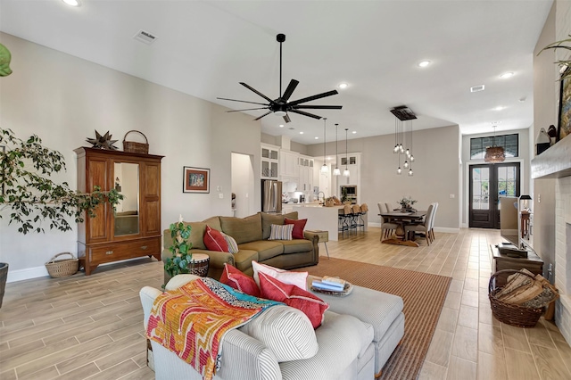 living room featuring ceiling fan and french doors