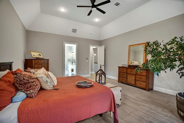 bedroom featuring ceiling fan, ensuite bathroom, light hardwood / wood-style flooring, and lofted ceiling