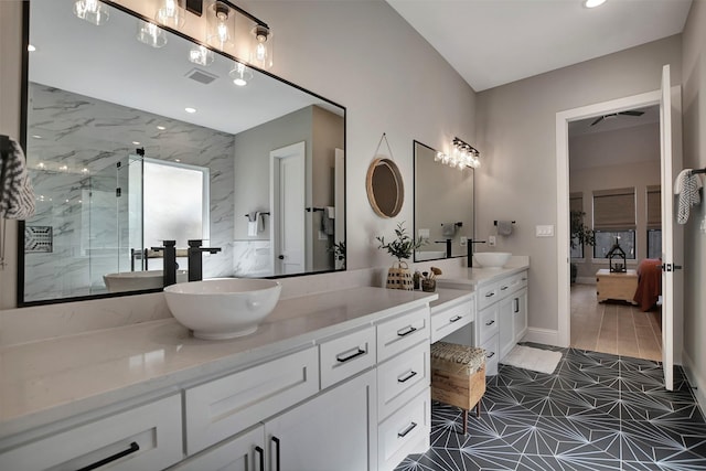 bathroom featuring a shower with shower door and vanity