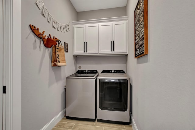 laundry room with washer and clothes dryer and cabinets