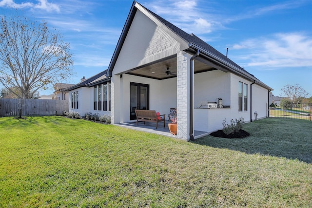 back of house with ceiling fan, an outdoor hangout area, a patio area, and a yard