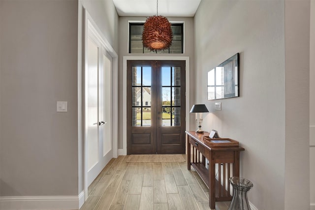 entryway with french doors and light hardwood / wood-style floors