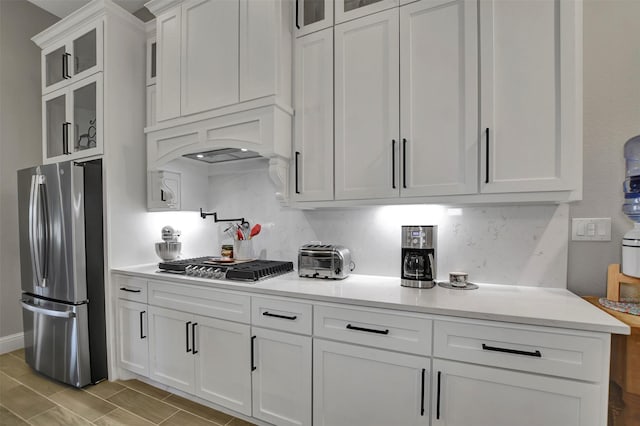 kitchen with decorative backsplash, white cabinets, and appliances with stainless steel finishes