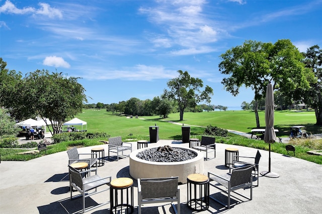 view of property's community with a patio area, an outdoor fire pit, and a yard