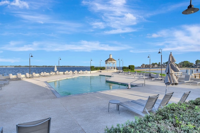 view of pool with a patio area and a water view