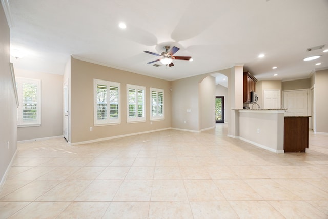 unfurnished living room featuring ceiling fan, light tile patterned floors, and ornamental molding