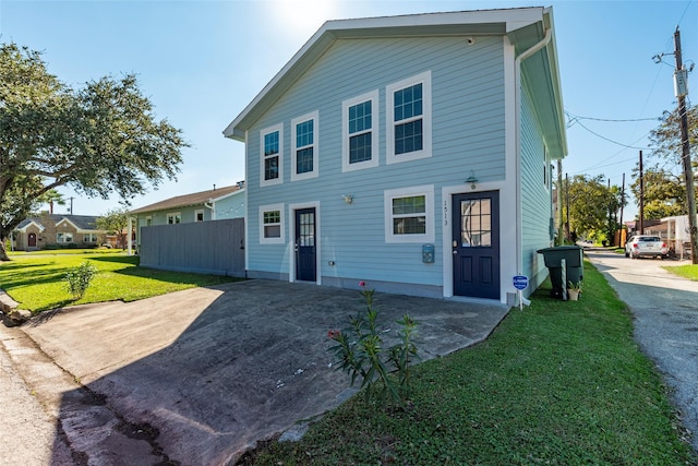 rear view of property featuring a lawn