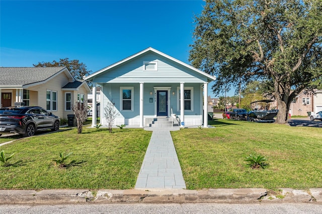 bungalow-style home featuring a front lawn and covered porch