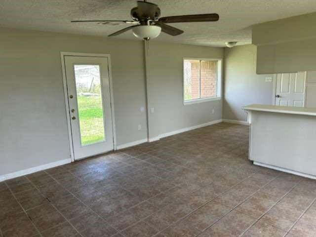 interior space featuring ceiling fan and plenty of natural light