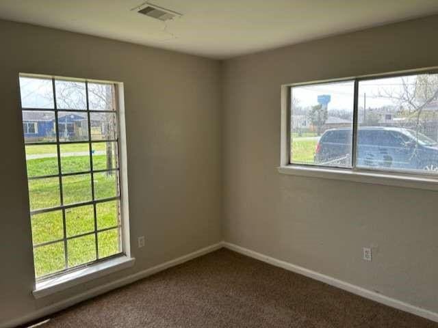 empty room with dark colored carpet