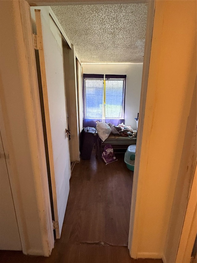 hallway with wood-type flooring and a textured ceiling