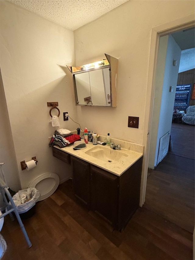 bathroom with a textured ceiling, hardwood / wood-style flooring, and vanity