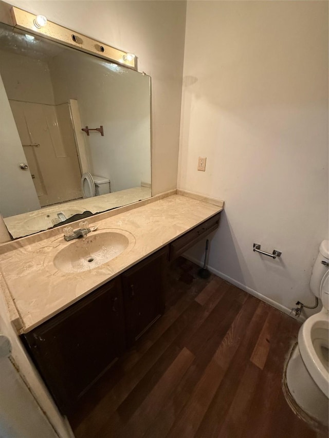 bathroom with toilet, vanity, walk in shower, and hardwood / wood-style floors