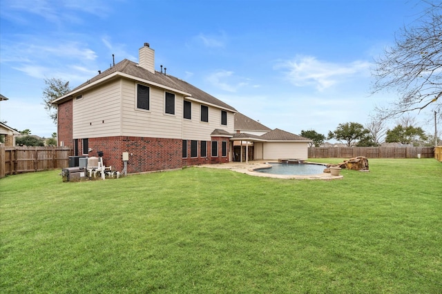 back of property with a patio area, a fenced in pool, and a yard