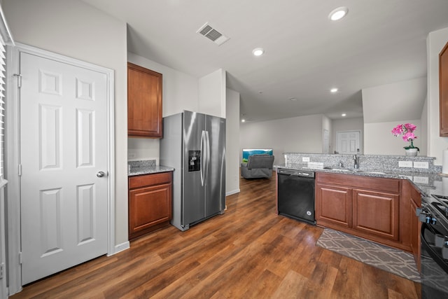 kitchen with black appliances, dark hardwood / wood-style flooring, sink, and light stone counters