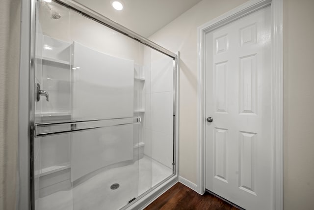 bathroom featuring a shower with shower door and hardwood / wood-style floors