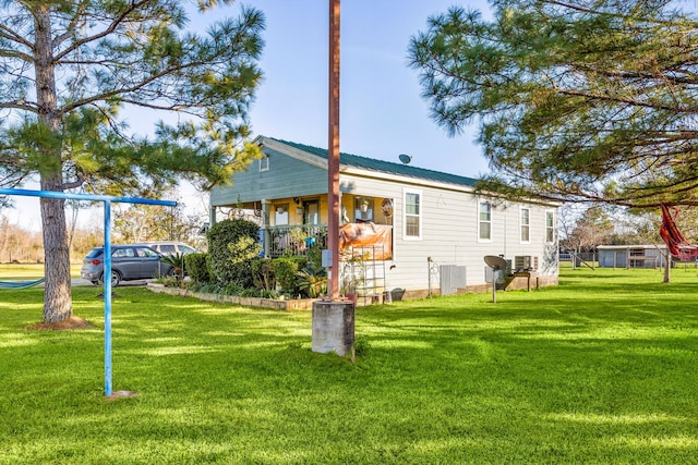 back of house featuring a lawn and central AC