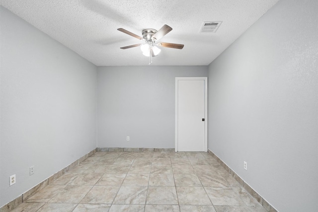 empty room featuring ceiling fan and a textured ceiling