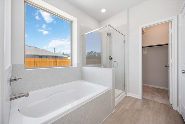 bathroom with wood-type flooring and independent shower and bath