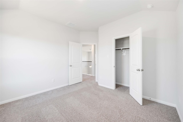 unfurnished bedroom featuring light colored carpet and a closet