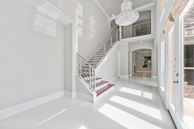 tiled foyer featuring a chandelier and a towering ceiling