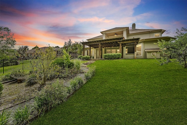 yard at dusk featuring a pergola