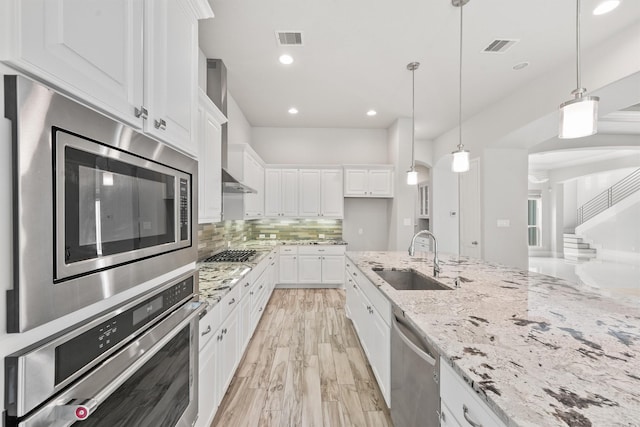 kitchen featuring pendant lighting, sink, white cabinetry, and appliances with stainless steel finishes