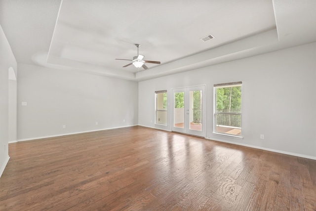 spare room with ceiling fan, dark hardwood / wood-style floors, and a raised ceiling