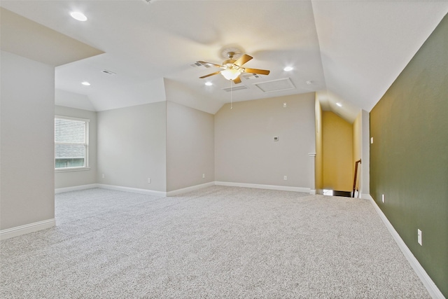 carpeted spare room featuring lofted ceiling, ceiling fan, and baseboards