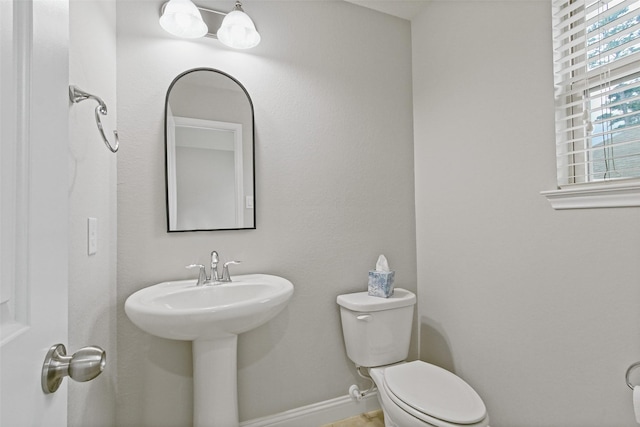 half bath with toilet and baseboards