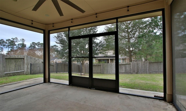 unfurnished sunroom with a ceiling fan