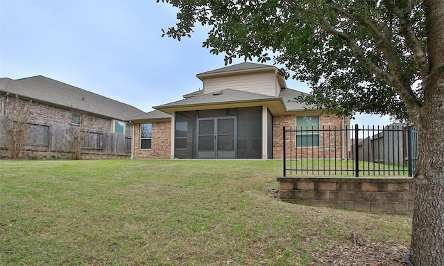 back of house featuring fence private yard, a lawn, and brick siding